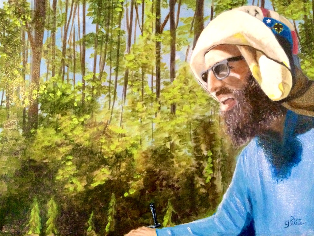Portrait ensoleillé d’un cycliste solitaire barbu portant un pull bleu et un chapeau avec un boisé en arrière-plan 
